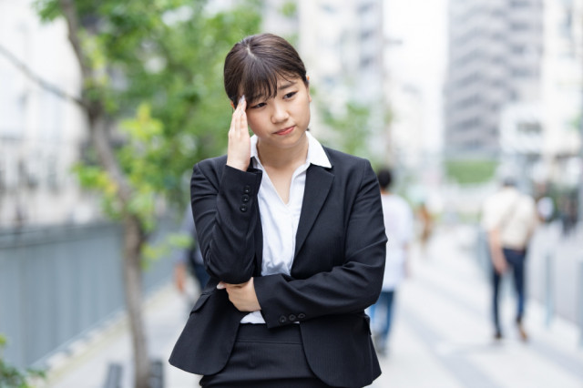 頭を抑える人の写真