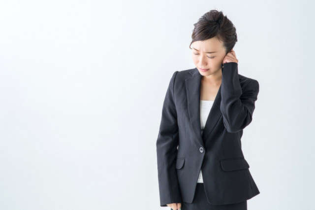 耳を抑える人の写真